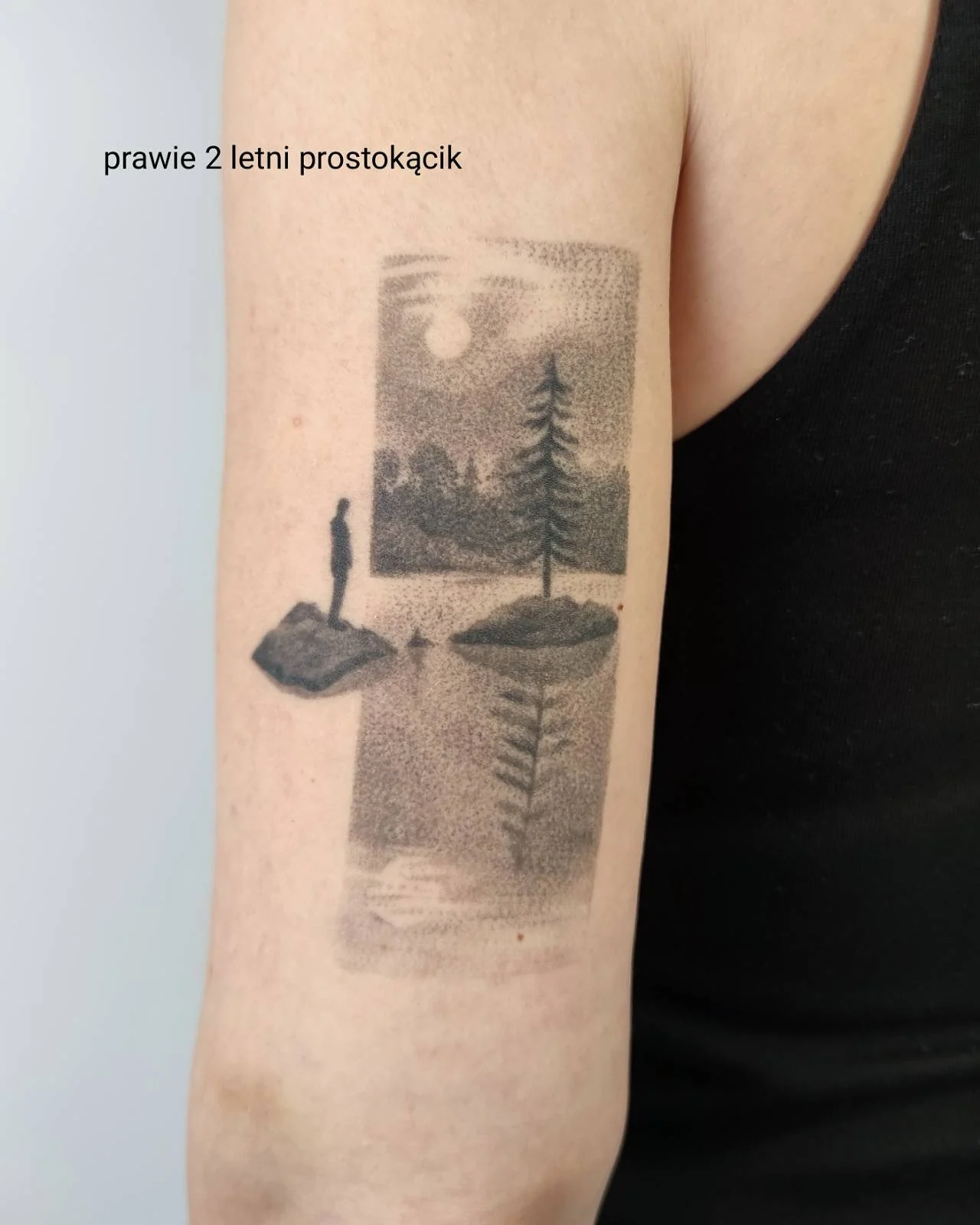 Zbliżenie tatuażu na ramieniu przedstawiającego fantastyczną postać z dużą, liściastą formą na głowie, wykonane w czarno-szarej tonacji., zdjęcie 6 z 6