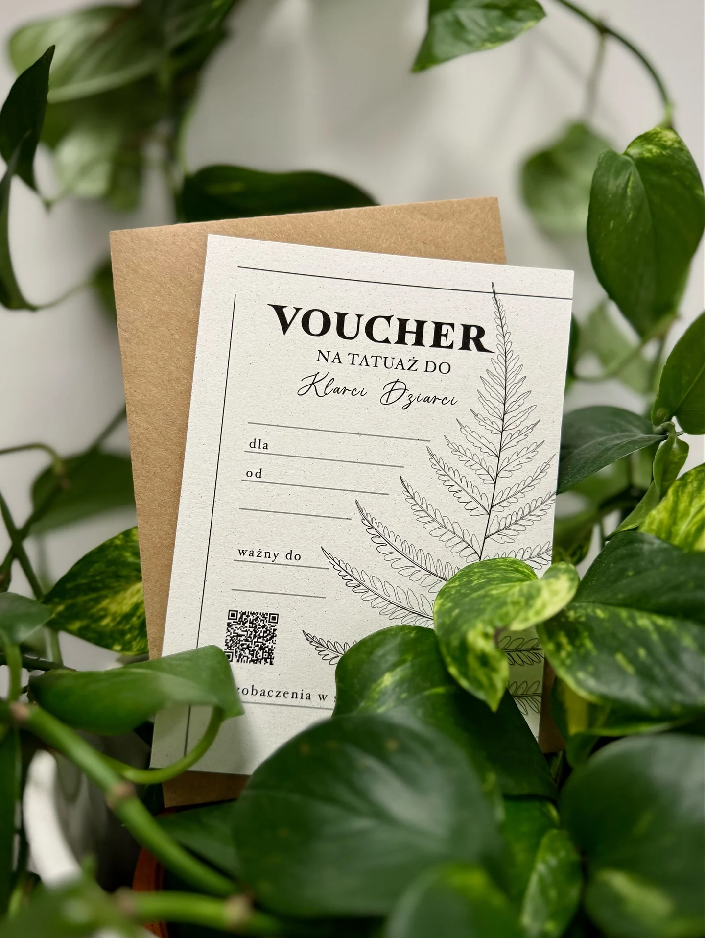 Voucher na tatuaż przedstawiony wśród roślin oraz przykładowe zdjęcia tatuaży, w tym portretów psów i sceny z osłem w prostokątnej kompozycji., zdjęcie 1 z 12