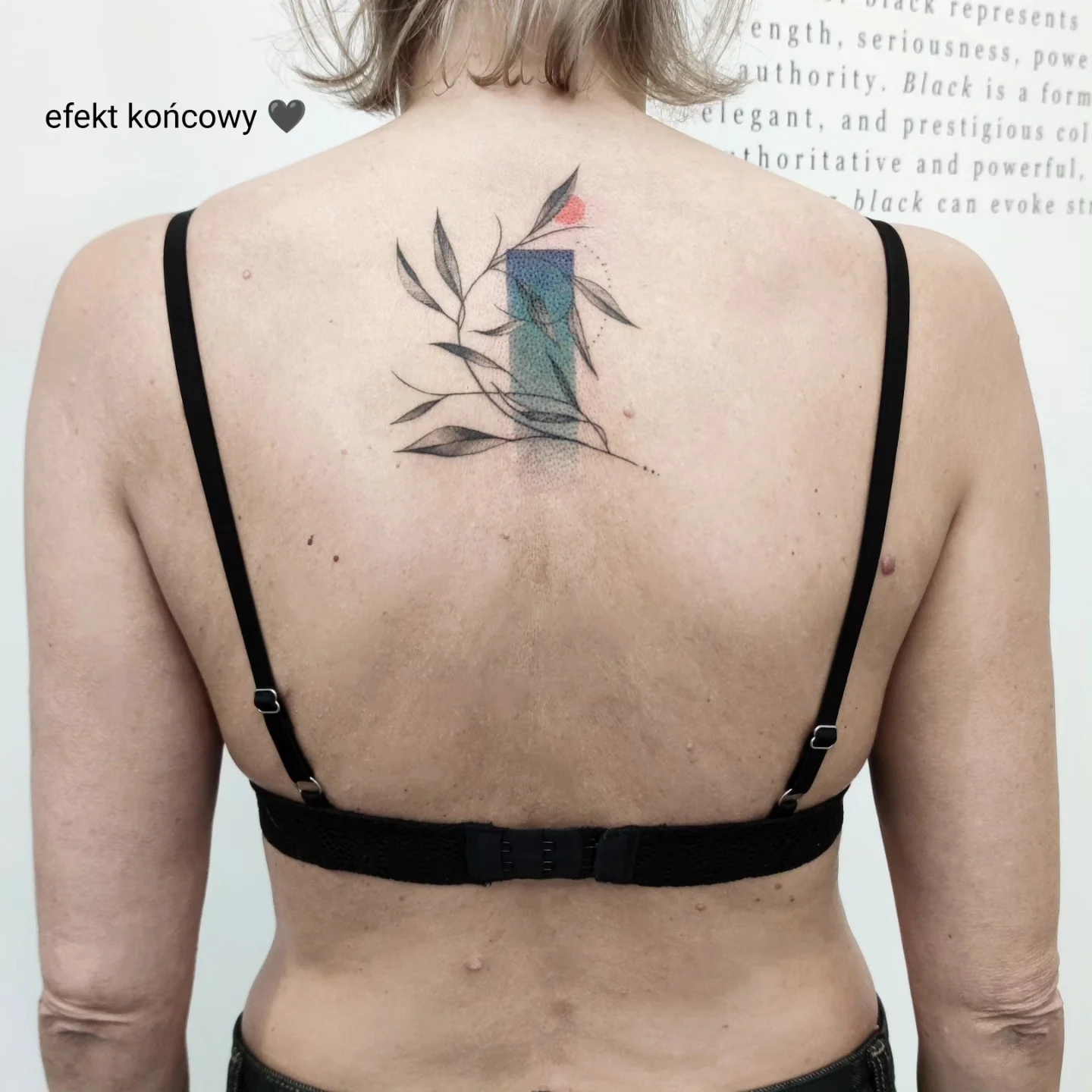 Karuzela pokazująca etapowy cover-up tatuażu na plecach: wcześniejszy wzór spirali i geometrycznych elementów został przykryty kompozycją z liśćmi, niebieskimi prostokątami i czerwonym akcentem., zdjęcie 5 z 6