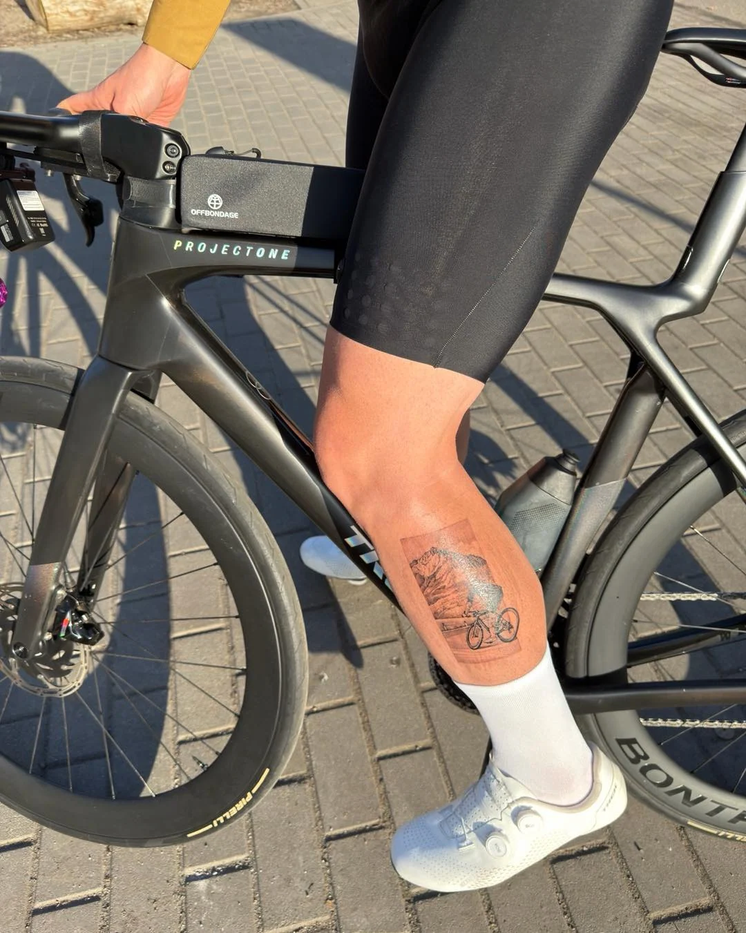 Karuzela przedstawia autorski tatuaż z rowerzystą na górskiej trasie oraz zdjęcie rowerzysty w górskim krajobrazie, które posłużyło jako inspiracja projektu., zdjęcie 5 z 5