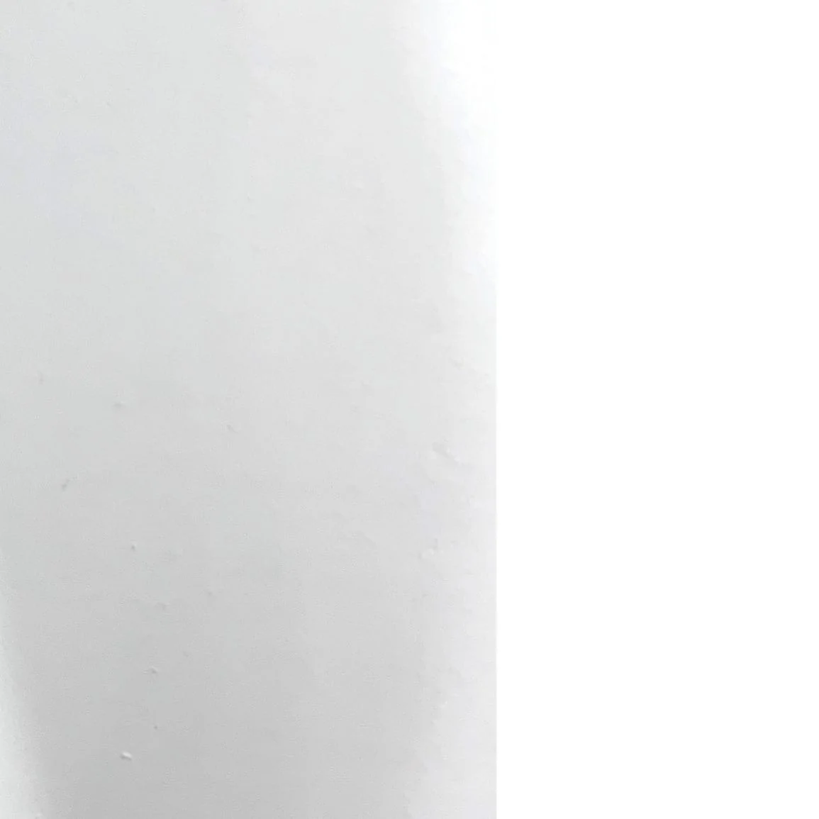 Minimalistyczny biały, geometryczny kadr z jasną powierzchnią i pionowym załamaniem.